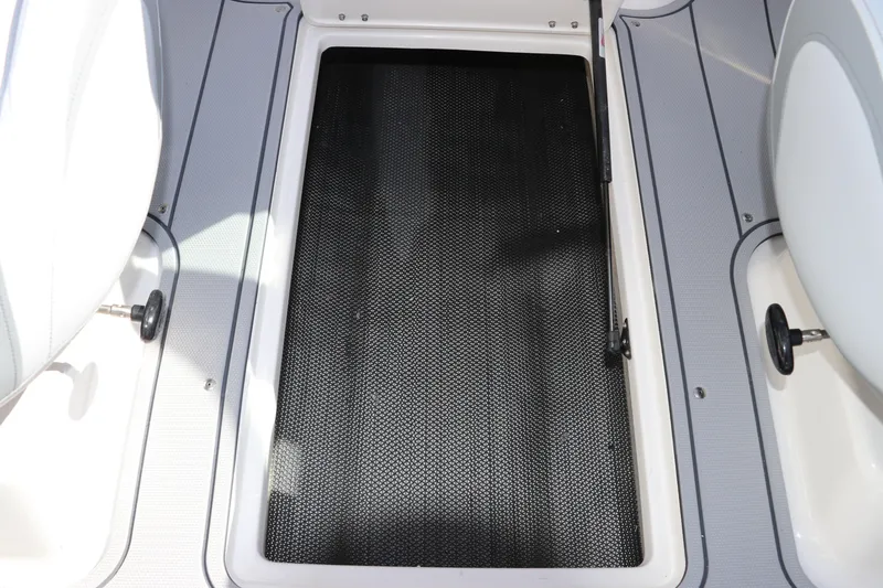Slide: The Image of 2026 Chaparral 21 SSi OB boat storage compartment with textured flooring. - 23