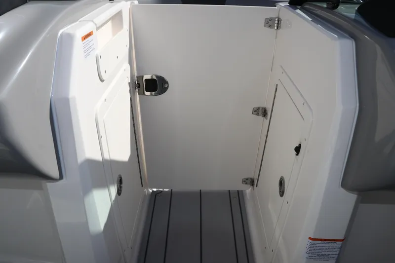 Slide: The Image of 2026 Chaparral 21 SSi OB boat interior storage compartment with open door. - 32