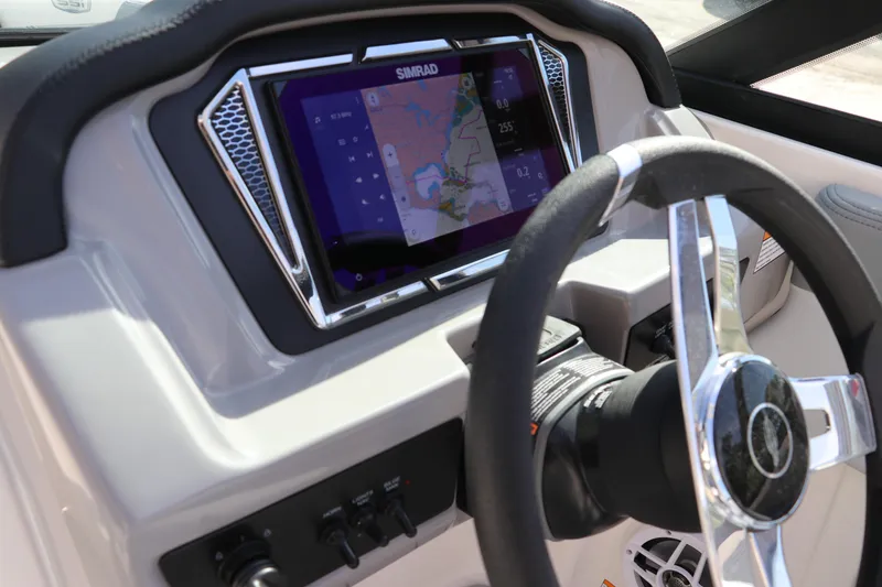 Slide: The Image of 2026 Chaparral 21 SSi OB boat dashboard with Simrad navigation display and steering wheel. - 39