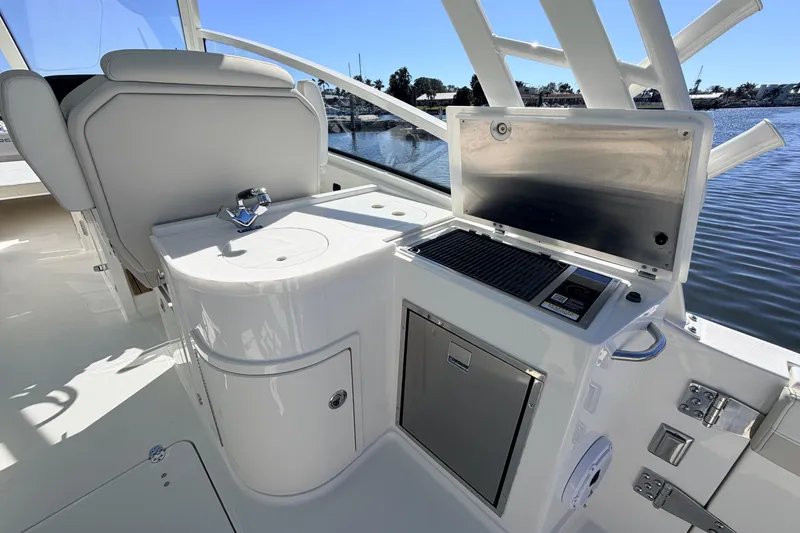 Slide: The Image of 2026 World Cat 325 DC boat interior with kitchenette and seating, overlooking water. - 11