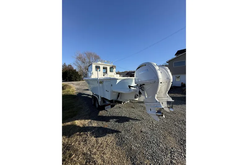 The Image of 2024 Parker 2520 XLD Sport Cabin boat with dual Yamaha engines on a trailer. - 0