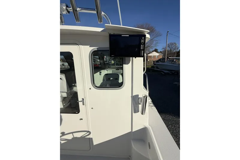 Slide: The Image of 2024 Parker 2520 XLD Sport Cabin boat exterior with navigation equipment. - 11