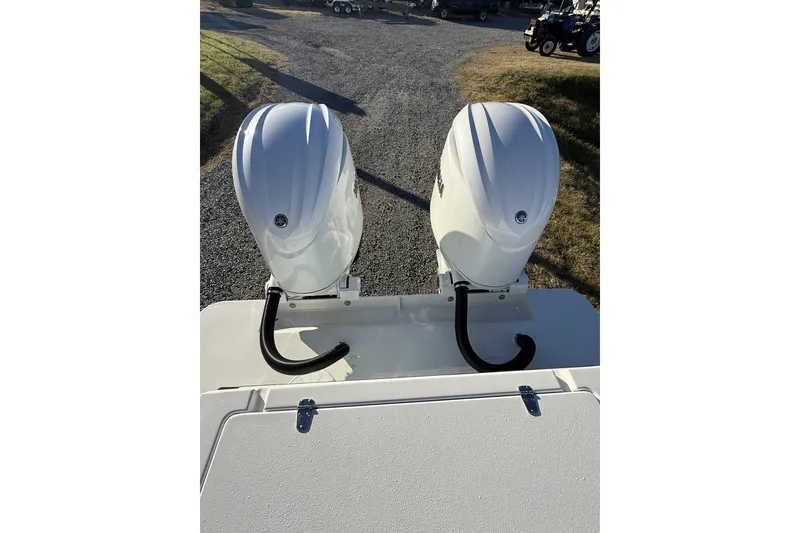 Slide: The Image of 2024 Parker 2520 XLD Sport Cabin with dual outboard motors on a gravel path. - 4