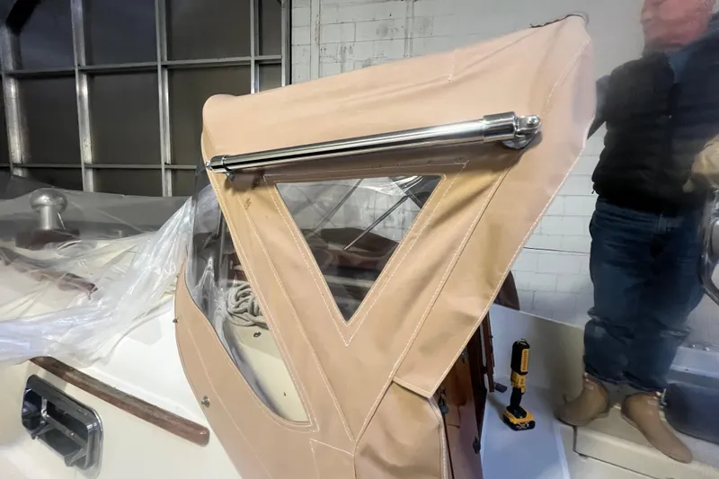 Slide: The Image of 1999 Southern Cross Cutter with tan canvas cover in a garage setting. - 12