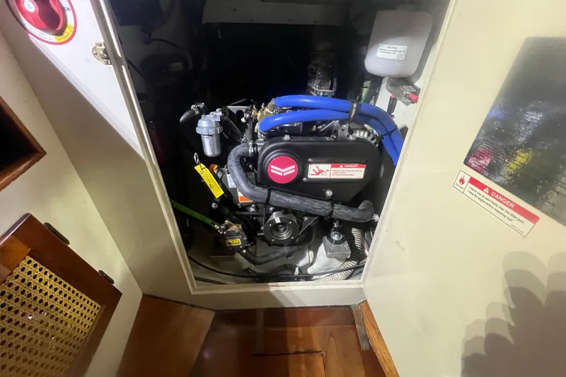 Slide: The Image of Engine compartment of a 1999 Southern Cross Cutter with visible components and warning labels. - 16