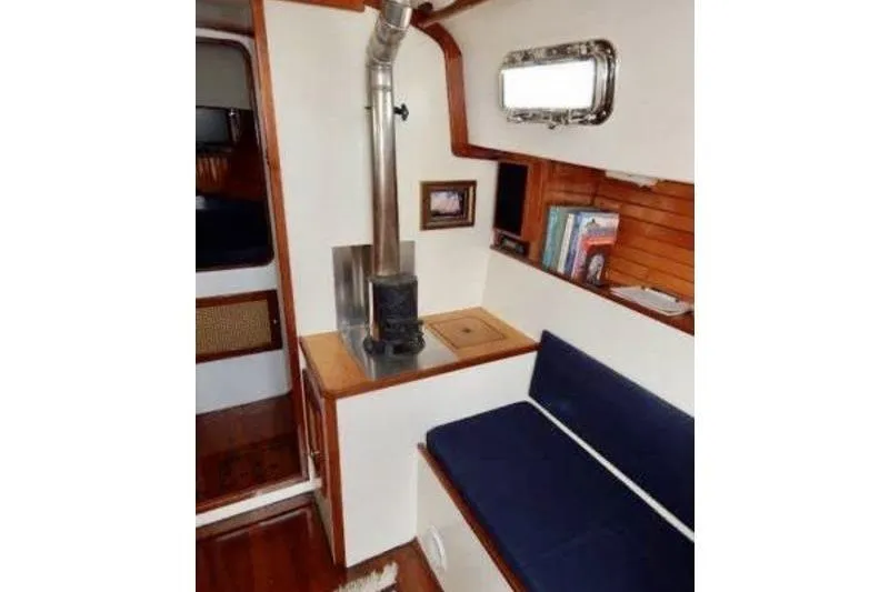 Slide: The Image of Interior of 1999 Southern Cross Cutter with stove, seating, and wooden accents. - 5