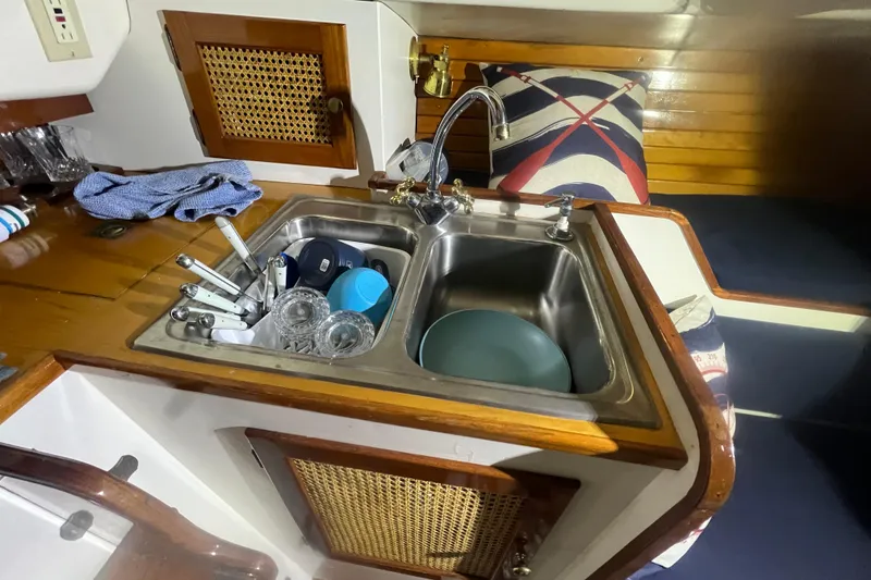 Slide: The Image of 1999 Southern Cross Cutter kitchen sink with dishes and nautical decor. - 6