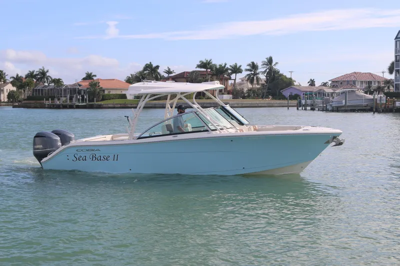 Slide: The Image of 2019 Cobia 280 Dual Console boat cruising on water with Yamaha engines. - 10