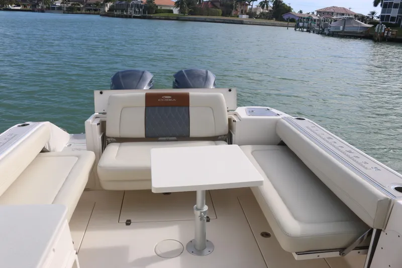 Slide: The Image of 2019 Cobia 280 Dual Console boat interior with seating, under clear blue sky. - 21