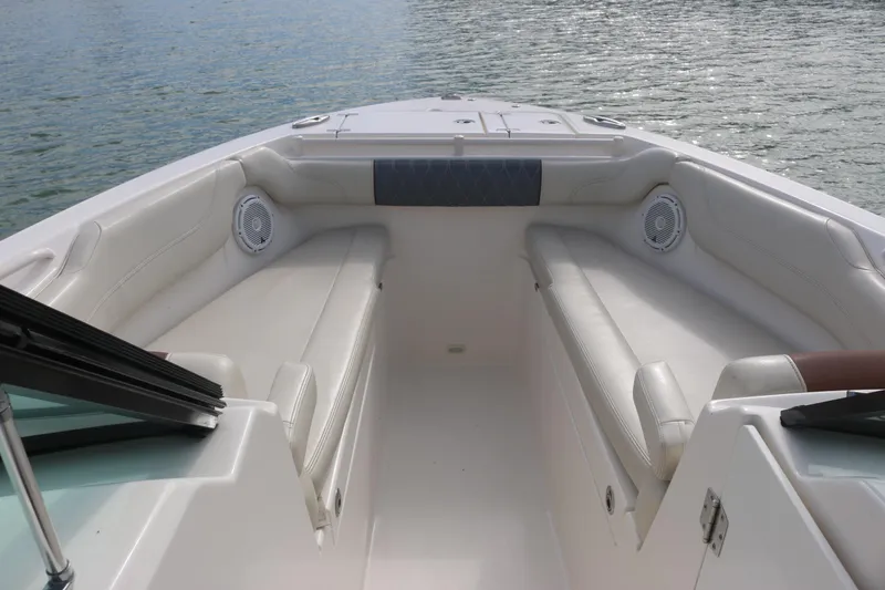 Slide: The Image of 2019 Cobia 280 Dual Console boat docked, featuring spacious seating and clear blue skies. - 30