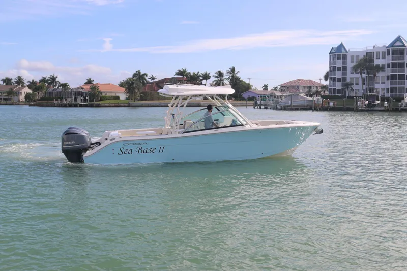 Slide: The Image of 2019 Cobia 280 Dual Console boat with twin Yamaha 250 engines on the water. - 36