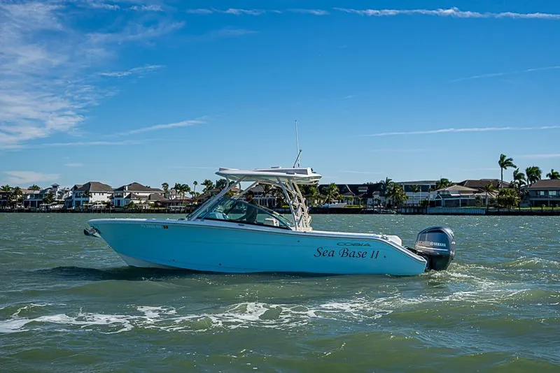 Slide: The Image of 2019 Cobia 280 Dual Console boat cruising on a sunny day near waterfront homes. - 39