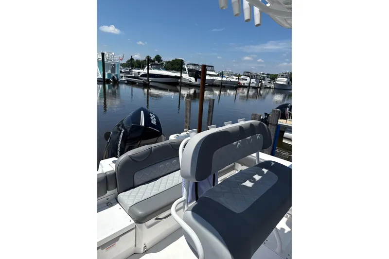 Slide: The Image of 2024 NauticStar 222L Offshore boat interior at marina, featuring comfortable seating. - 4