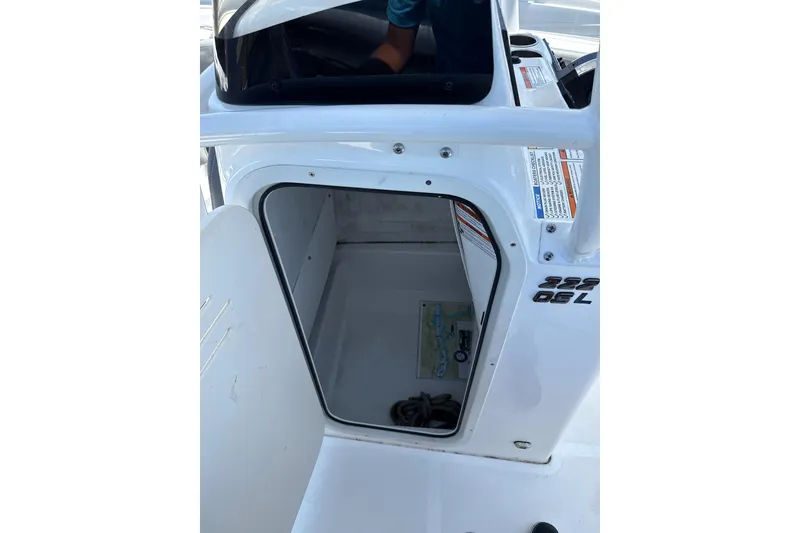 Slide: The Image of 2024 NauticStar 222L Offshore boat storage compartment with open door. - 8
