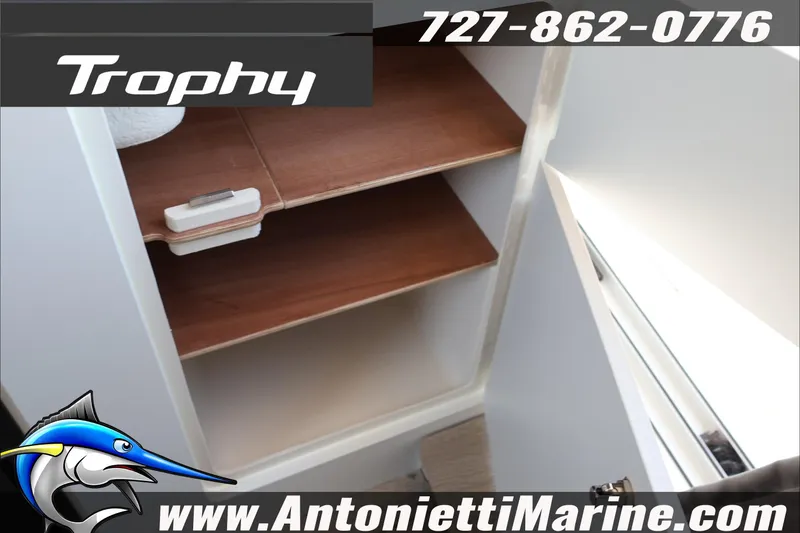 Slide: The Image of 2026 Bayliner Trophy T23 Explorer interior storage shelves, featuring wooden finish. - 39