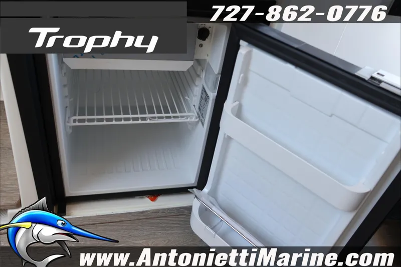 Slide: The Image of Open refrigerator on 2026 Bayliner Trophy T23 Explorer boat, featuring storage shelves. - 41