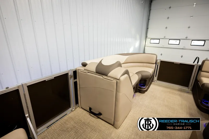 Slide: The Image of 2022 Avalon LSZ QL pontoon boat interior with beige seating in a garage setting. - 23