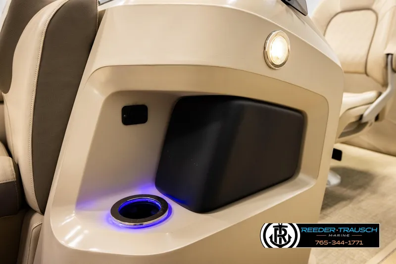 Slide: The Image of 2022 Avalon LSZ QL boat interior with illuminated cup holder and beige seating. - 44