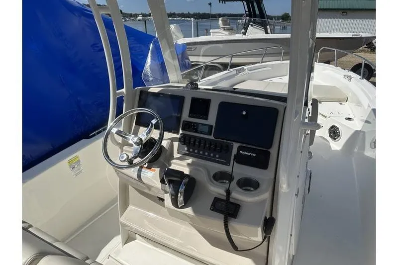 Slide: The Image of 2021 Boston Whaler 250 Dauntless boat console with steering wheel and navigation controls. - 4