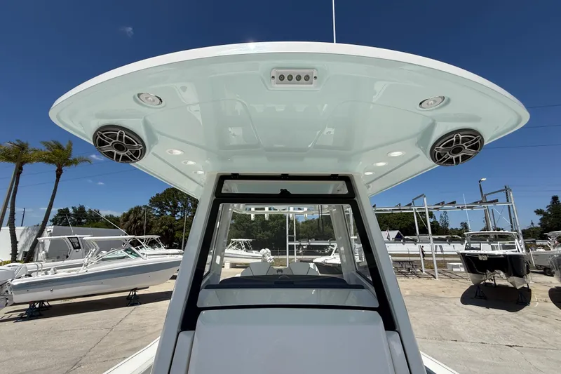 Slide: The Image of 2026 World Cat 265 CC-X boat with speakers and canopy, docked under clear blue sky. - 11