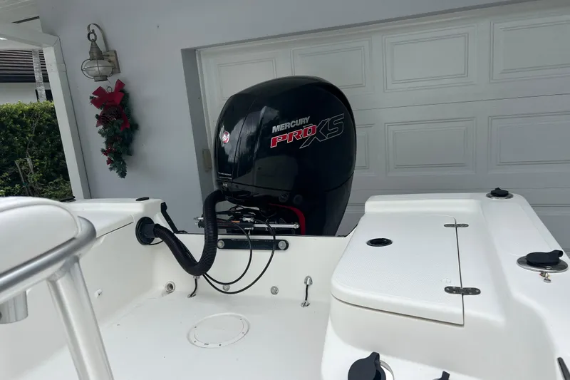 Slide: The Image of 2005 Mako 2101 Inshore boat with Mercury Pro XS engine in a garage setting. - 10