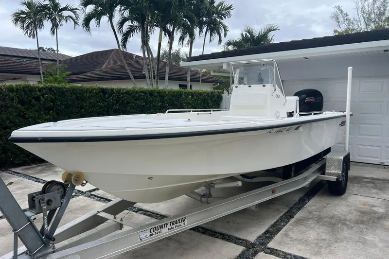 The Image of 2005 Mako 2101 Inshore boat on trailer, parked in driveway with palm trees. - 2