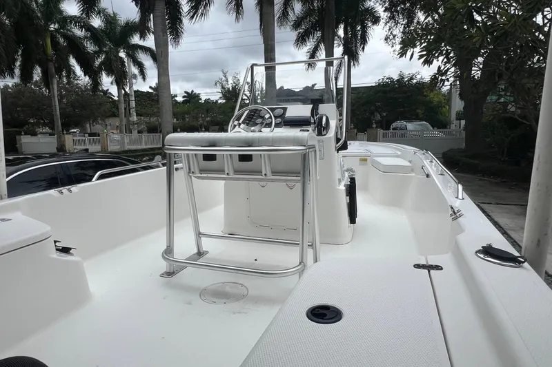 Slide: The Image of 2005 Mako 2101 Inshore boat with center console, parked outdoors near palm trees. - 21