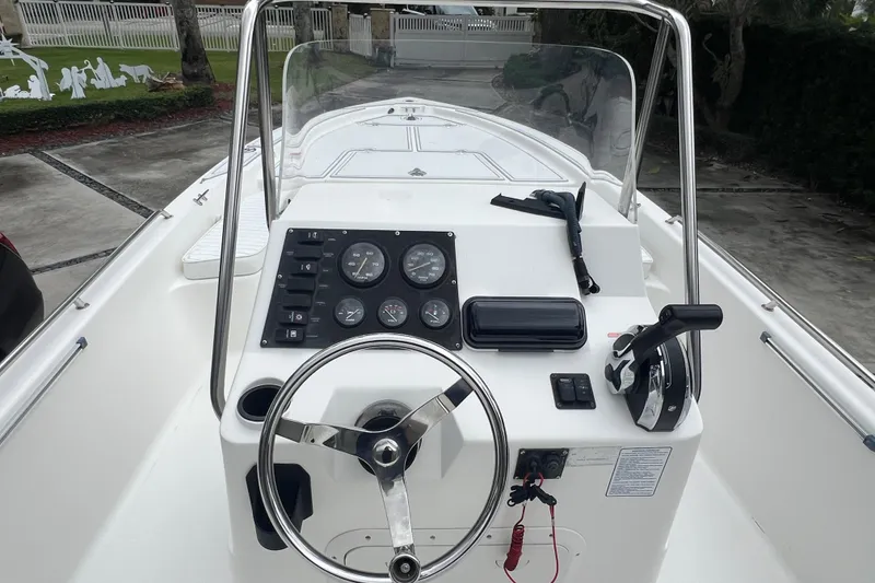 Slide: The Image of 2005 Mako 2101 Inshore boat dashboard with steering wheel and control panel. - 29