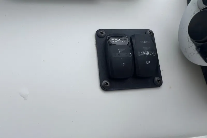 Slide: The Image of Boat control panel with two switches labeled "DOWN" and "UP" on a Mako 2101 Inshore. - 30