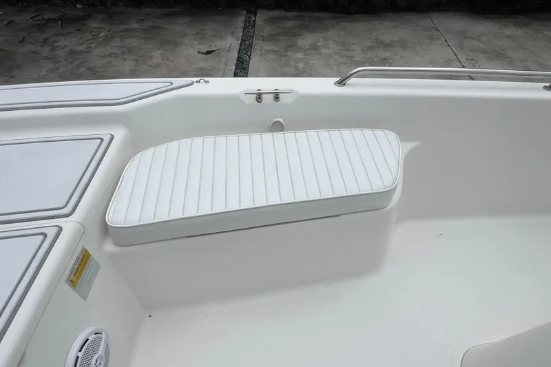 Slide: The Image of 2005 Mako 2101 Inshore boat interior with white cushioned seating and storage compartments. - 37