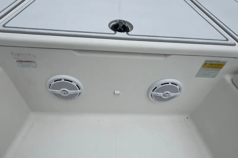 Slide: The Image of 2005 Mako 2101 Inshore boat interior with dual speakers and storage compartment. - 38