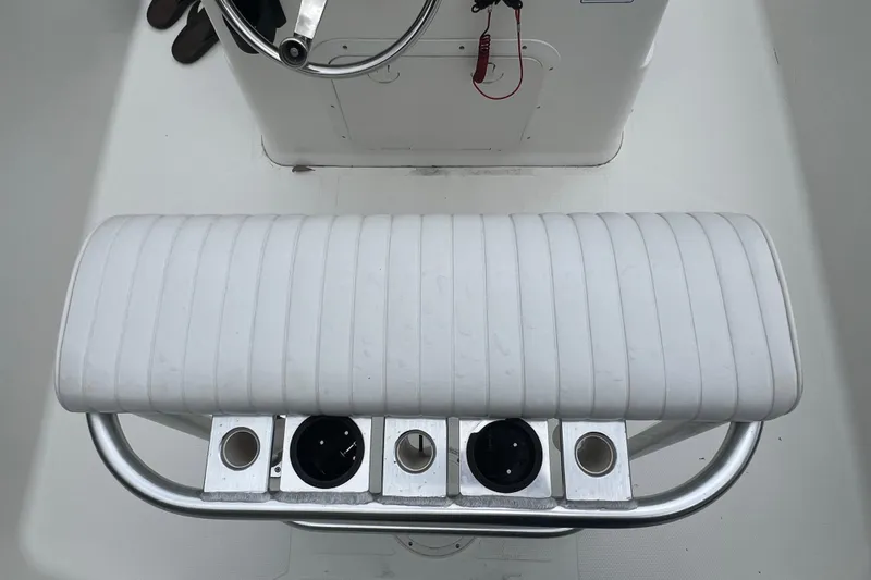 Slide: The Image of 2005 Mako 2101 Inshore boat console with white cushioned seat and rod holders. - 42