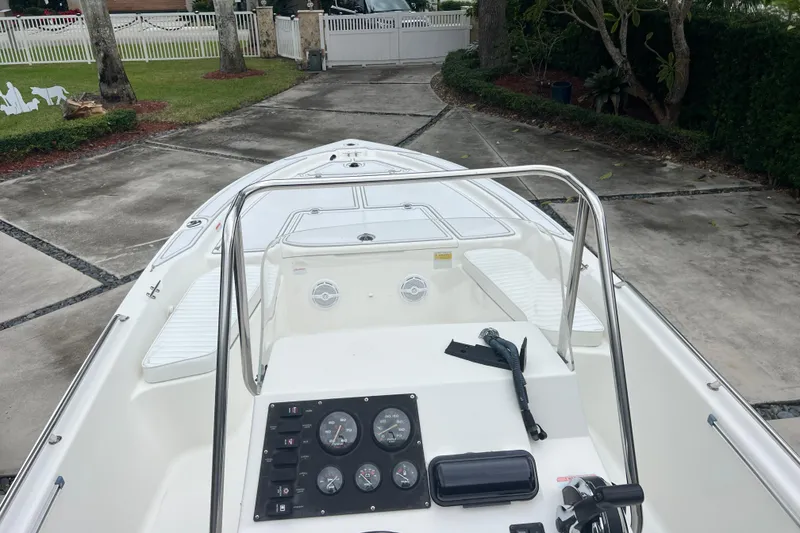 Slide: The Image of 2005 Mako 2101 Inshore boat, white interior, parked in driveway with trees and fence. - 45