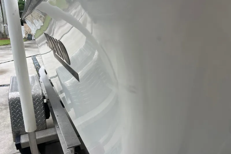 Slide: The Image of 2005 Mako 2101 Inshore boat on trailer, side view with reflective surface. - 48