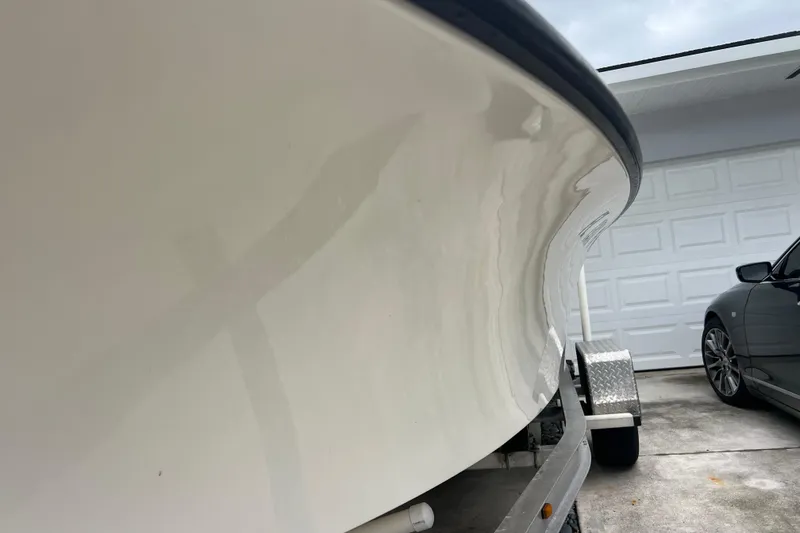 Slide: The Image of 2005 Mako 2101 Inshore boat on trailer beside a car in driveway. - 7