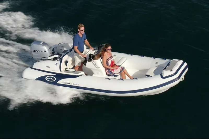 Slide: The Image of Manufacturer Provided Image: 2025 Walker Bay Venture 16 boat cruising with two passengers on a sunny day. - 1
