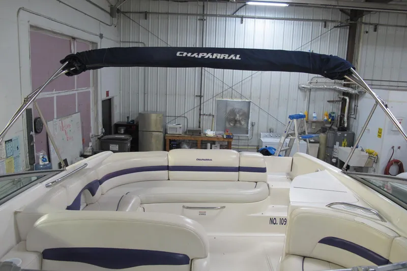 Slide: The Image of 1999 Chaparral 2830 SS boat interior with seating and canopy in a workshop. - 3