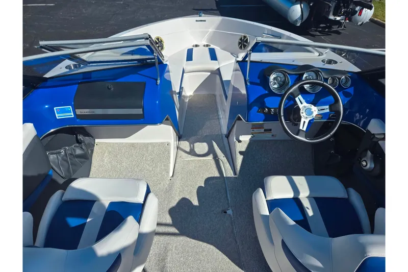 Slide: The Image of 2013 Glastron GT 205 boat interior with blue and white seating, steering wheel, and dashboard. - 12
