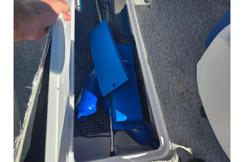 Slide: The Image of Storage compartment in a 2013 Glastron GT 205 boat with blue accessories. - 13