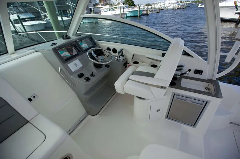 Slide: The Image of Manufacturer Provided Image: 2016 Boston Whaler 315 Conquest helm station with modern controls and waterfront view. - 5