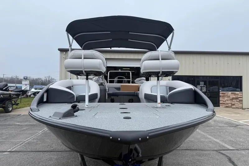 Slide: The Image of 2026 Lowe Sport Deck 224 boat with canopy, parked outside a building. - 2