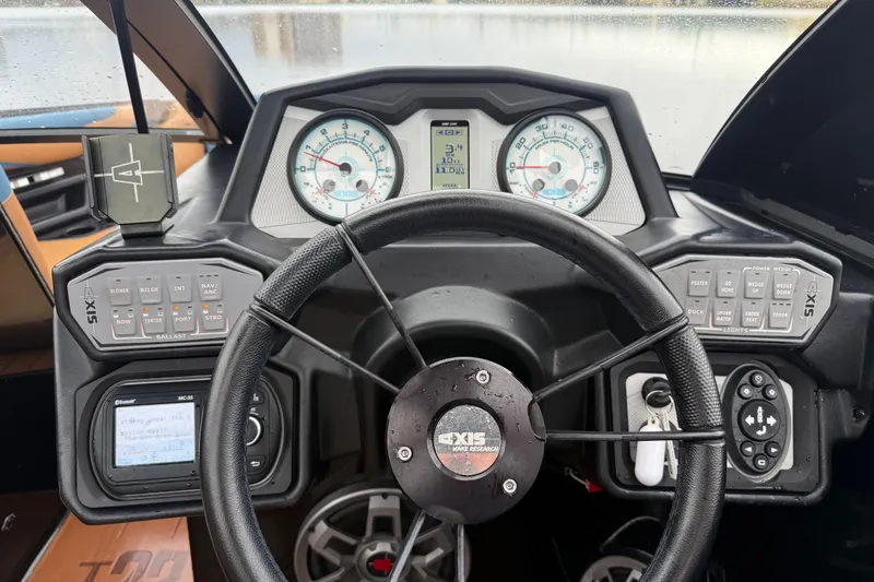 Slide: The Image of 2021 Axis T23 boat dashboard with steering wheel, gauges, and control panels. - 12