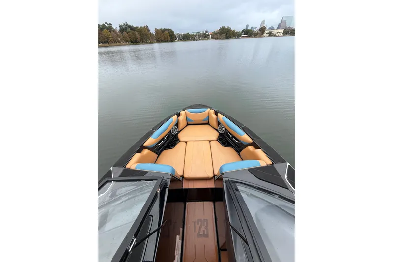 Slide: The Image of 2021 Axis T23 boat with tan and blue seating on a calm lake. - 13