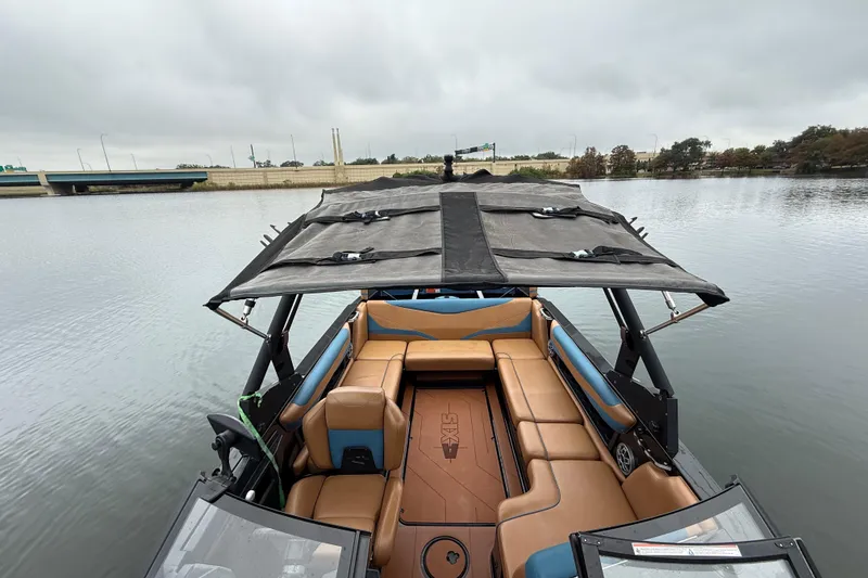Slide: The Image of 2021 Axis T23 boat with tan seating and canopy on a calm lake. - 14