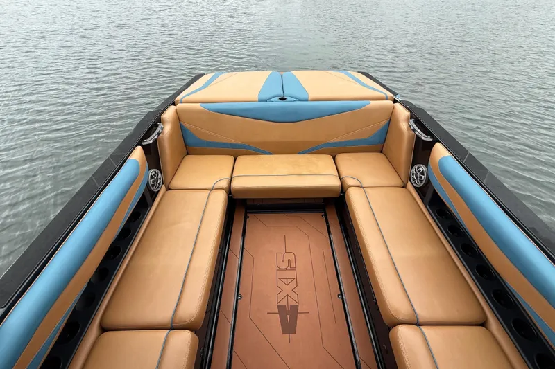 Slide: The Image of 2021 Axis T23 boat interior with tan and blue seating on calm water. - 16