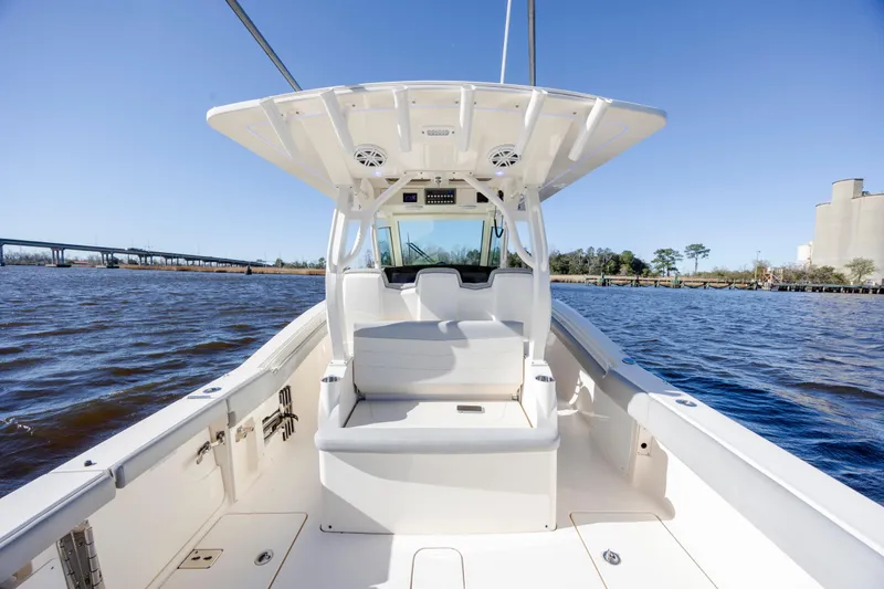 Slide: The Image of 2019 Scout 355 LXF boat interior on a sunny day, with water and bridge in background. - 17