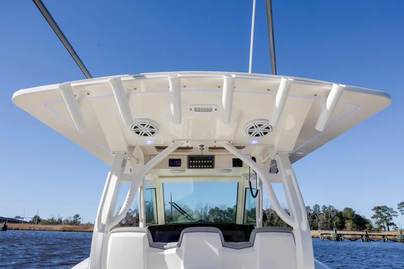 Slide: The Image of 2019 Scout 355 LXF boat helm with speakers and electronics under a clear blue sky. - 20