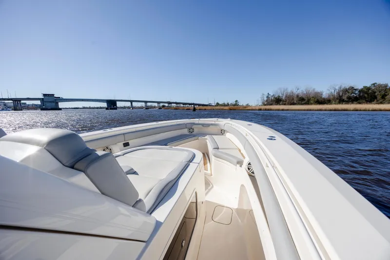 Slide: The Image of 2019 Scout 355 LXF boat cruising on a sunny day near a bridge. - 28