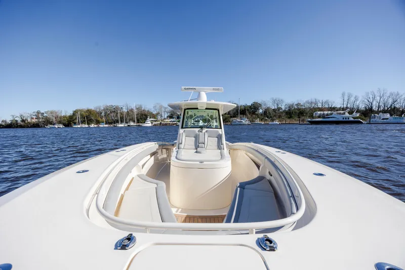 Slide: The Image of 2019 Scout 355 LXF boat on water, clear sky, luxurious seating. - 31