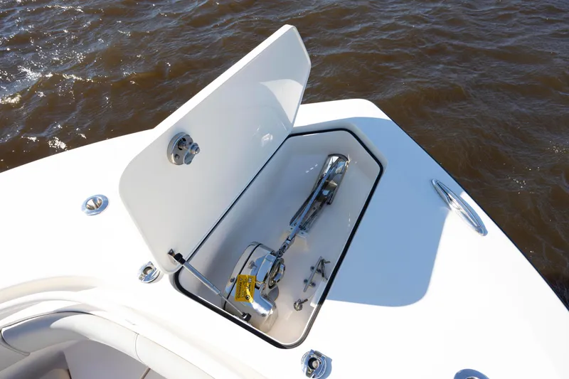 Slide: The Image of 2019 Scout 355 LXF boat anchor compartment open on water. - 33